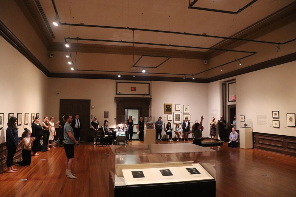 Group of students standing in the background of a large art gallery.