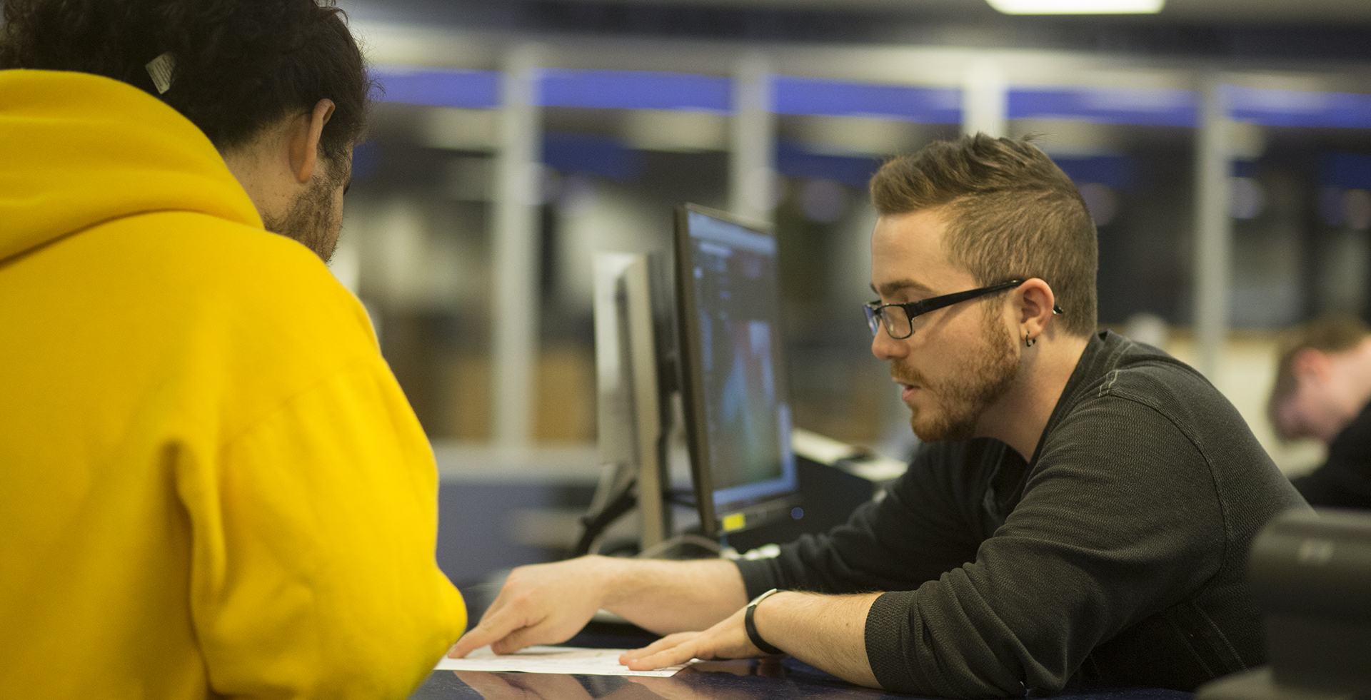 Tyler Haupt helps a student at the SMDC service desk.