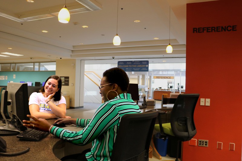 A student speaks with a Librarian at the Morris Library Reference Desk