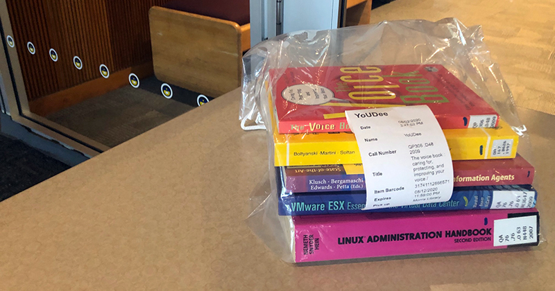 A stack of books in a clear bag sitting on a table.