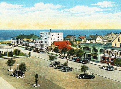 A color postcard of Rehoboth Avenue showing paved roads and parked cars