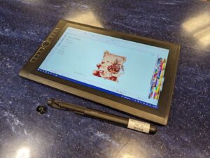 A tablet with stylus pen that is open to a graphic design program.