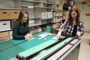 View of two student staff members preparing materials for an exhibition