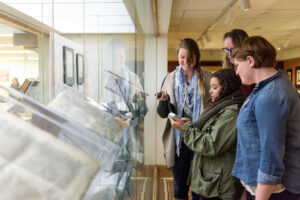 Group of Art Conservation students in the Special Collections exhibition gallery recording environmental data as part of a class project