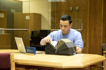 Researcher examining a rare book in the Special Collections Reading Room