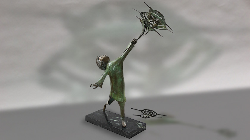 A bronze sculpture of a girl flying a group of kites